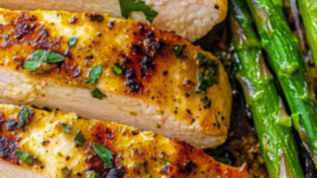 One-pan garlic butter chicken thighs with crispy golden skin resting over roasted broccoli, baby potatoes, zucchini, and cherry tomatoes in a cast iron skillet