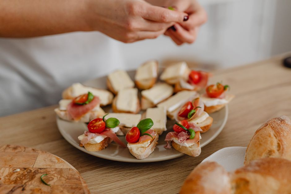 Bacon-wrapped dates stuffed with goat cheese arranged on a white serving platter, golden brown and glistening, garnished with fresh thyme